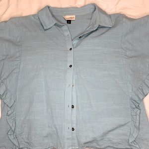 Blue button up with ruffle sleeves.